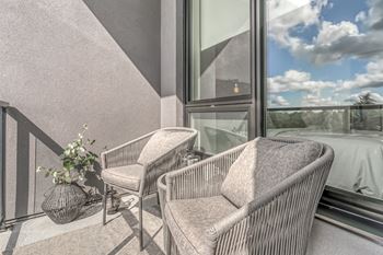 Two chairs and a table on a balcony